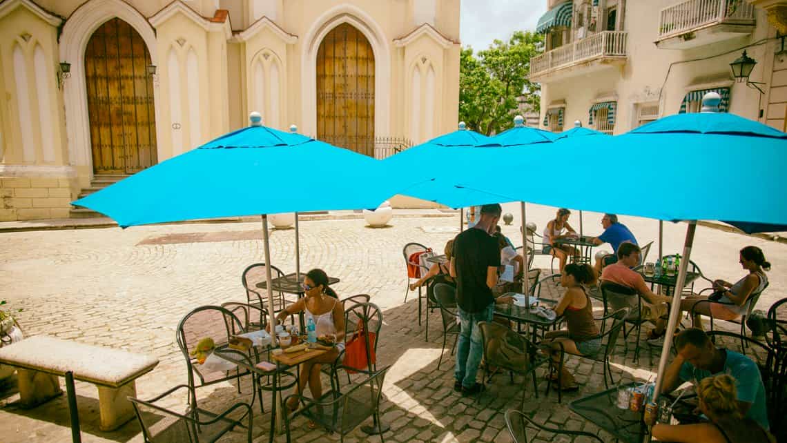 Turistas y habaneros disfrutan de un cafe al frescon en la Plazuela del Angel