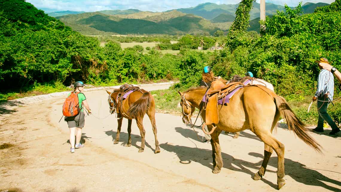 Turistas y guia recorren la Sierra del Escambray con sus caballos