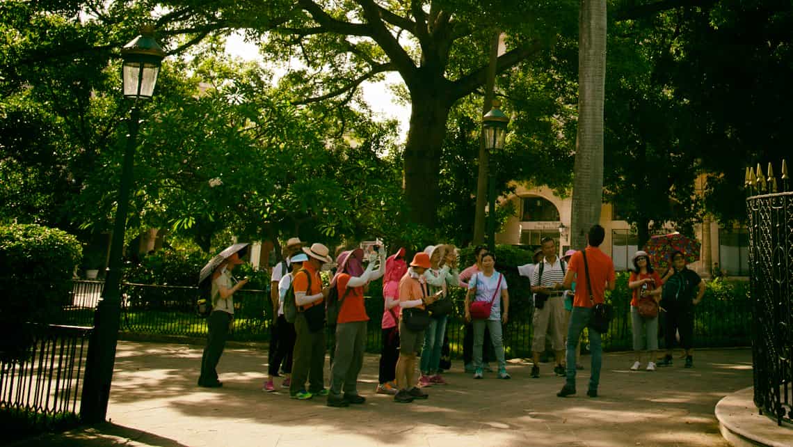 Turistas se reunen con guia en la Plaza de Armas de la Habana Vieja
