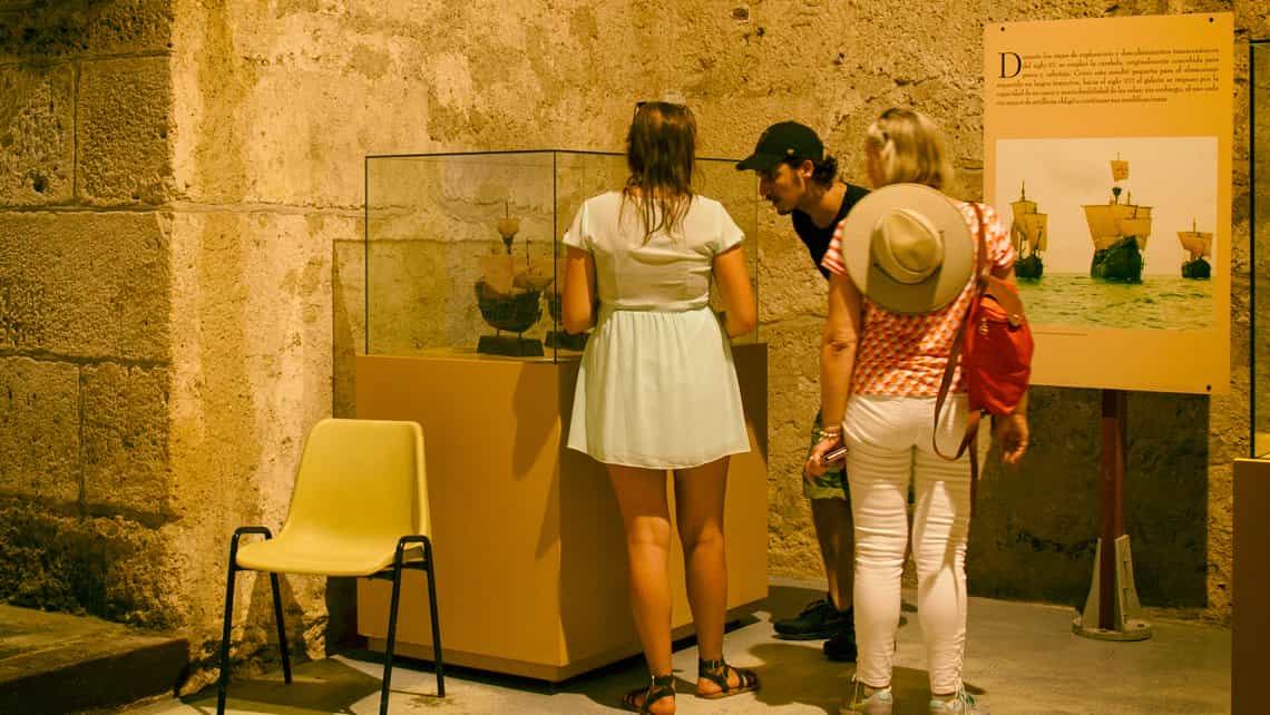 Viajeros observan artefactos en exposicion en el museo del Castillo de la Fuerza