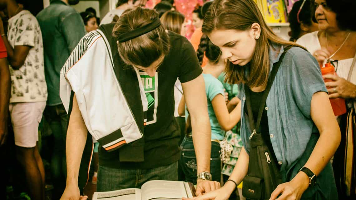 Jovenes leen un libro durante la Feria de La Habana