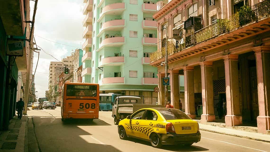 Taxi y autobus circulan por la Calle Belascoaín de Centro Habana