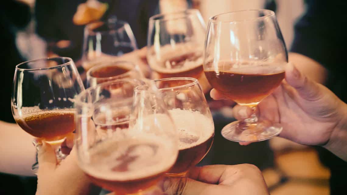 Viajeros brindan con cerveza Cristal en el Bar Esencia del Vedado Habanero