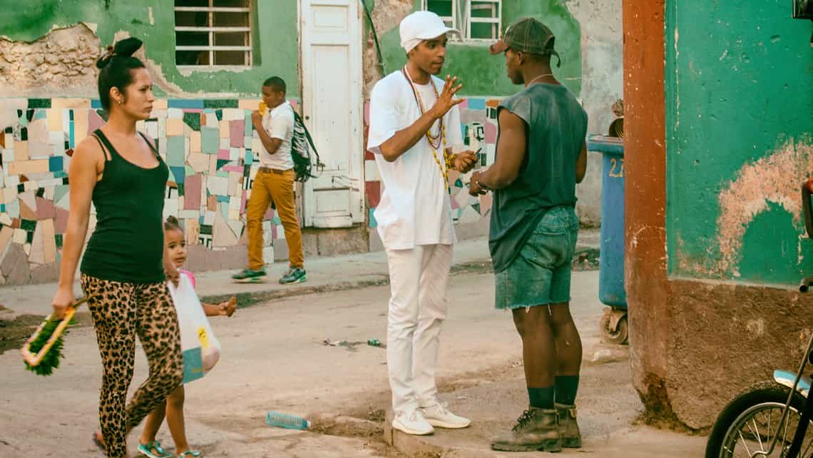 Muchacho, vestido de 'ssanto', conversa con un amigo en las calles de La Habana Vieja