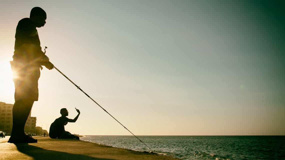 Pescador prueba suerte en el Malecon Habanero