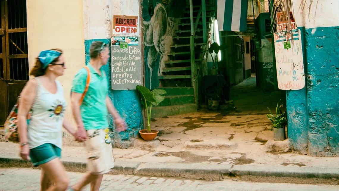 Turistas observan la entrada a un solar en el barrio de Centro Habana