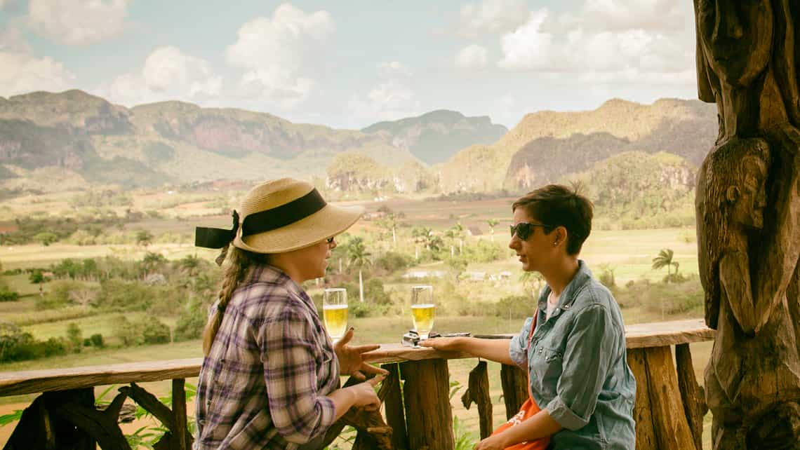 Turistas disfrutan de cerveza y la vista del Valle de Viñales desde el Talle Raices