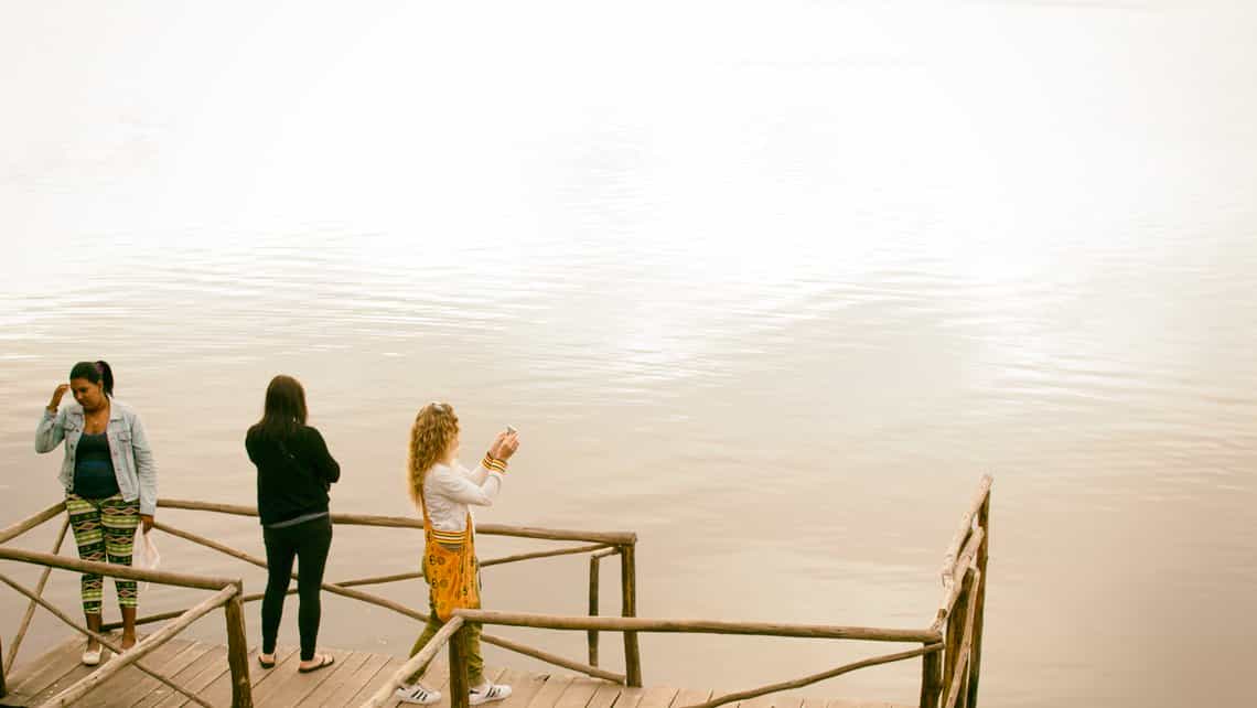 Turistas toman fotos de la laguna de Guanaroca desde el muelle rustico