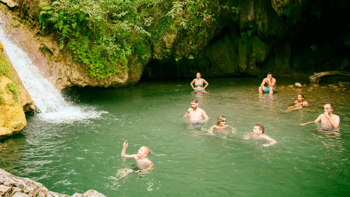 Viajeros disfrutan de las frescas aguas del rio en Hoyo del Pilón