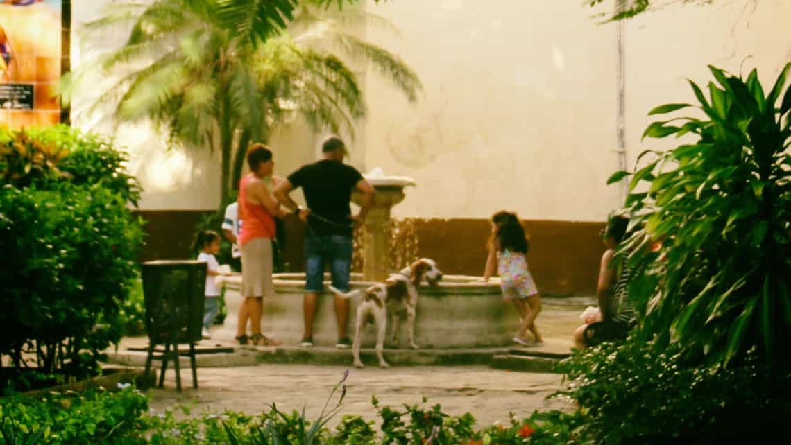 Familia pasea con su perro por la Calle Mercaderes de La Habana Vieja