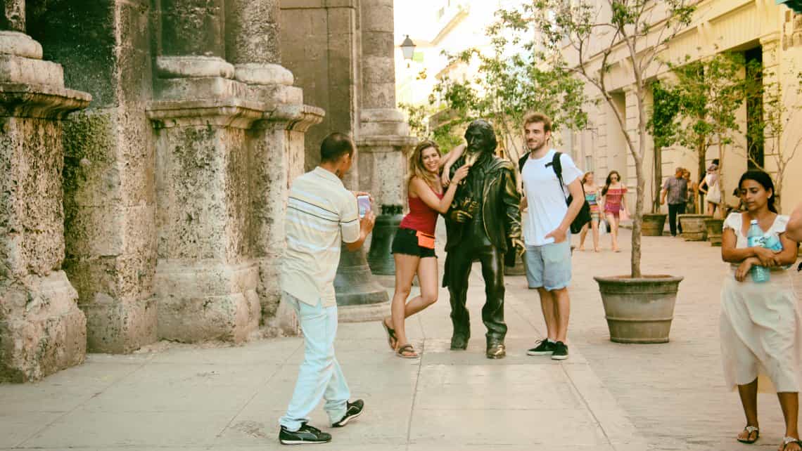 Turistas se toman fotos con la estatua del Caballero de Paris en la Plaza de San Francisco de Asis en La Habana Vieja
