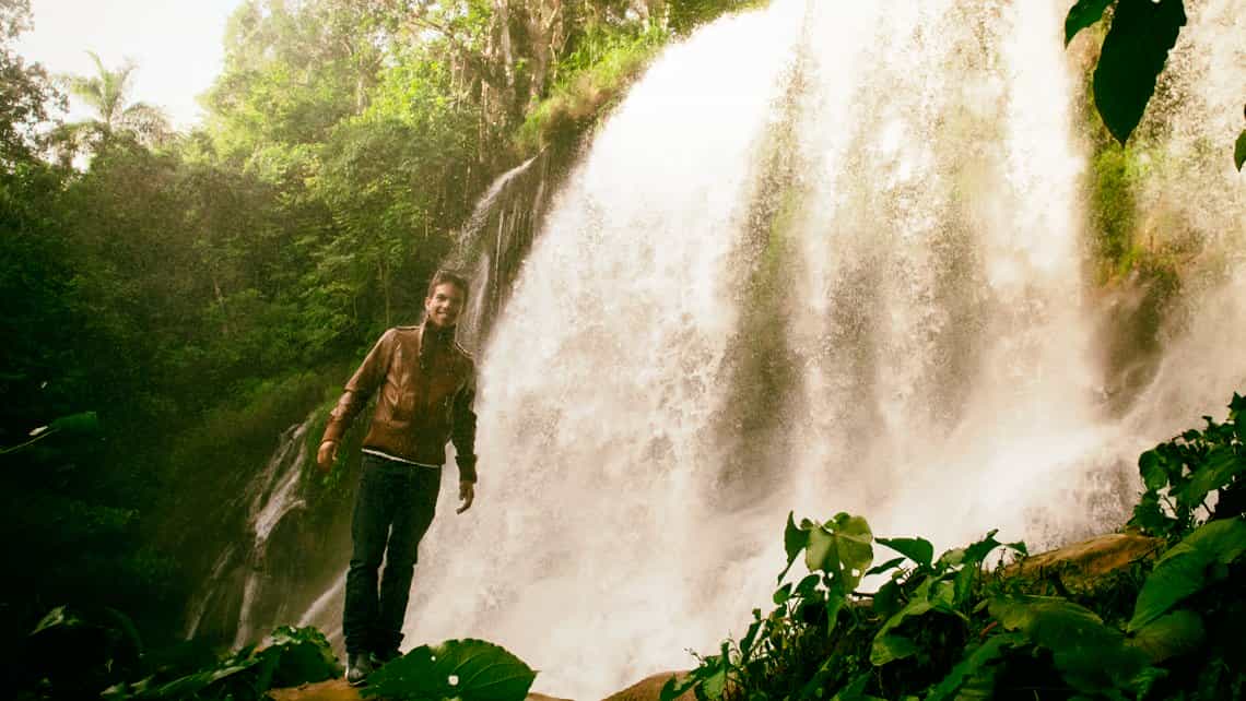 Turista posa en frenete de una de las cascadas del Nicho