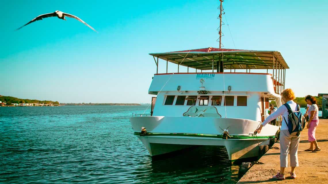 Turistas abordan un barco de paseo en la Bahi de Cienfuegos