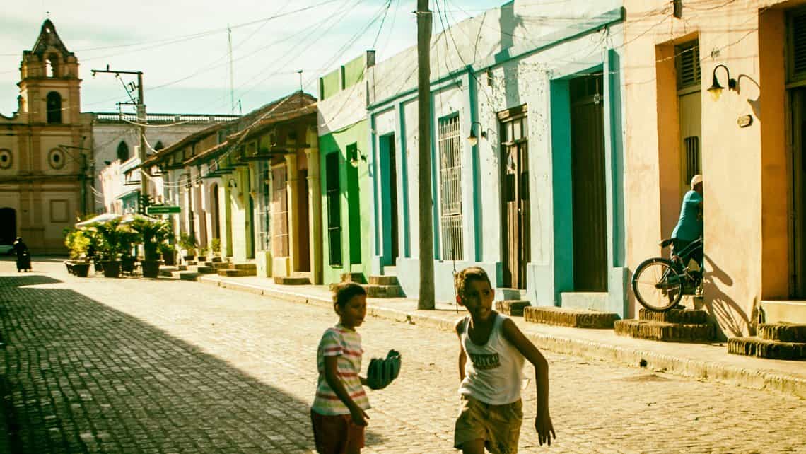 Muchachos juegan al besibol en la Plaza de San Juan de Dios de Camaguey, al fond la iglesia del mismo nombre