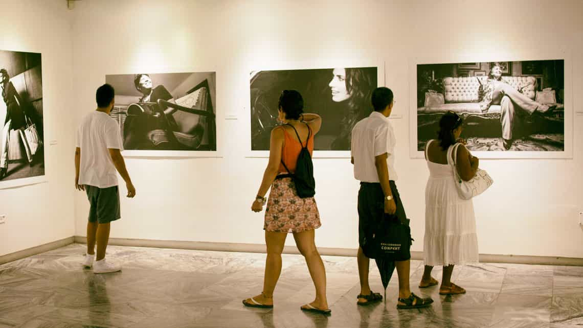 Hbanaeros se mezclan con turistas en exposicion fortografica en una galeria de arte de La Habana Vieja