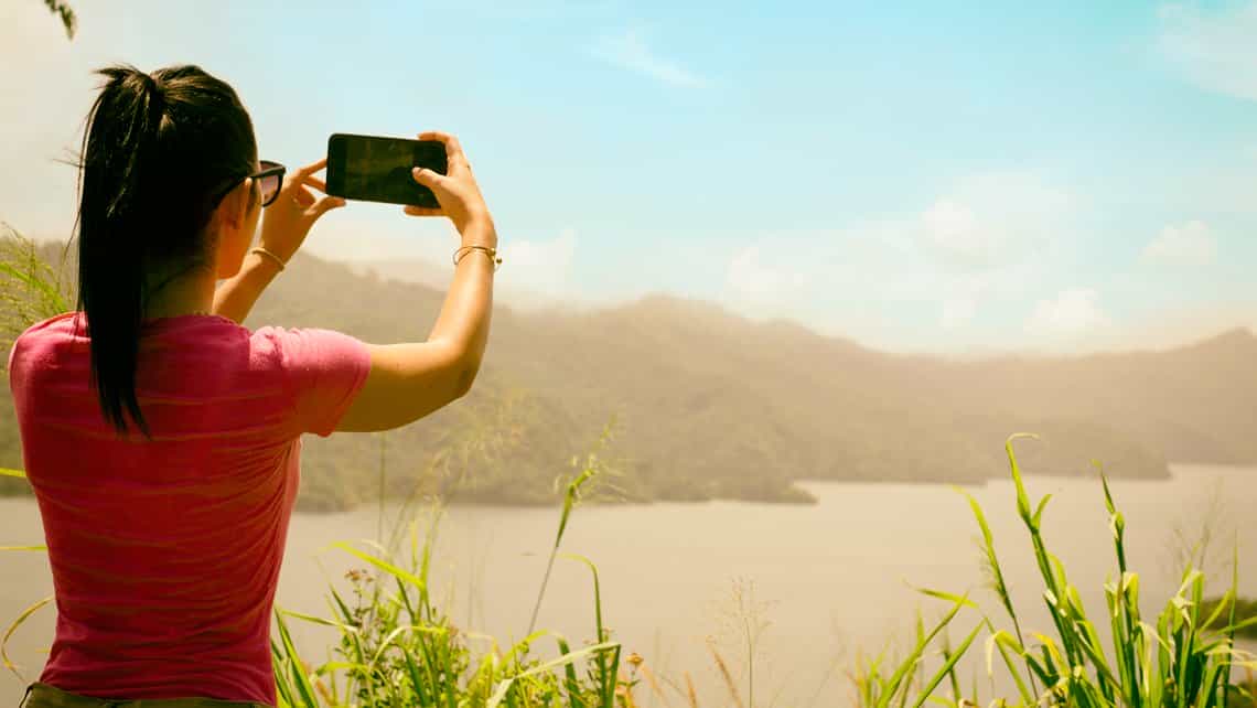Turista toma fotos de las colinas en la rivera del rio Yumuri