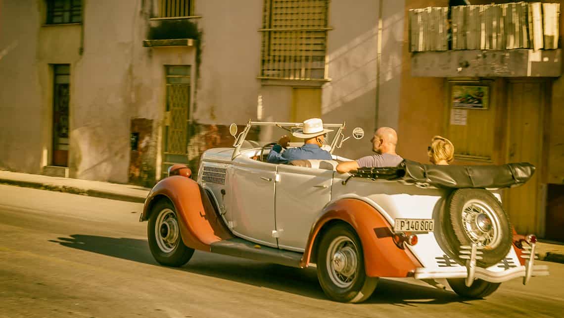 Turistas recorren la Calle Zanja en coche descapotable de los años 30