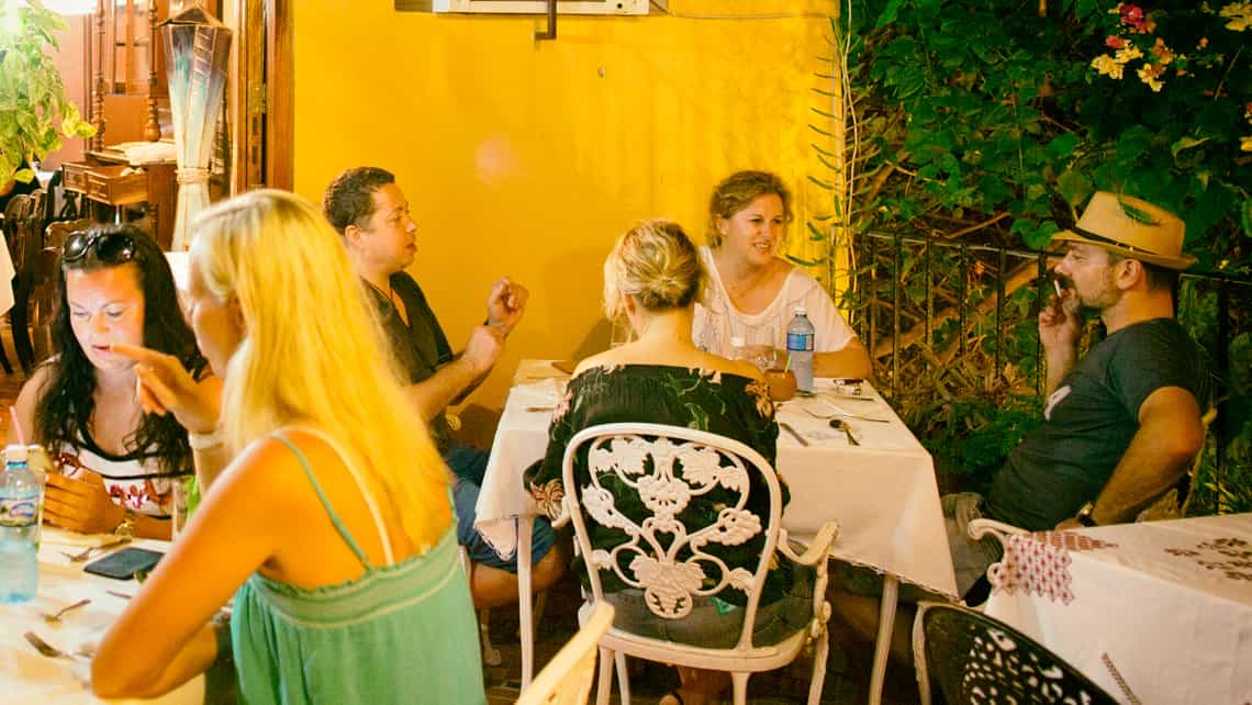 Viajeros conversan mientras cenan en la paladar Los Conspiradores