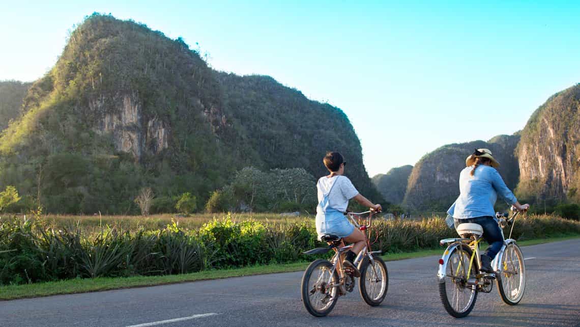 Turistas recorren el Valle de Viñales en bicicleta