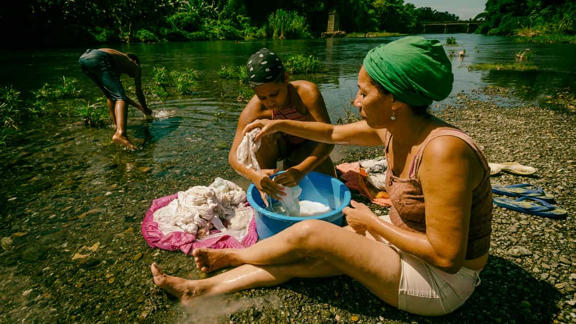 Mujeres lavan la ropa en las aguas del rio Toa