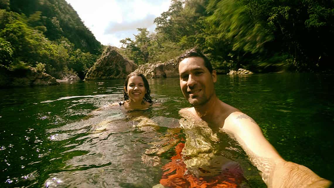 Turistas se toman fotos mientras se banan en las aguas del rio Toa en Baracoa