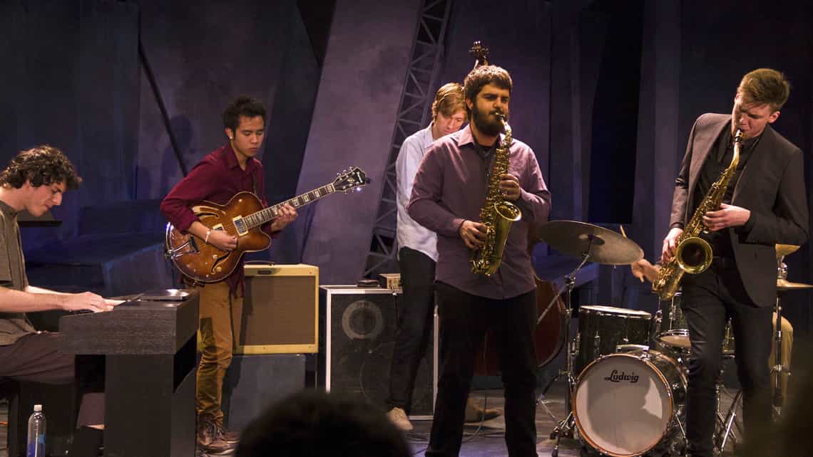 Jazzistas tocan saxofon, guitarra y piano en el escenario de festival cubano
