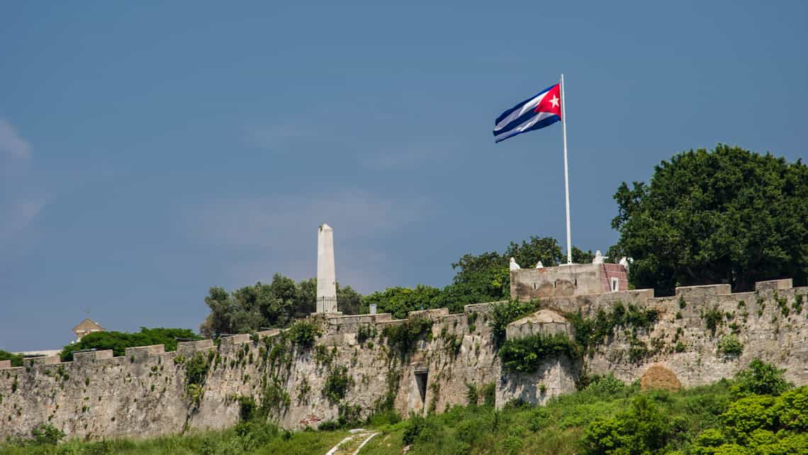 Bandera cubana ondea en los muros de la Fortaleza de la Cabana, vista desde la Avenida del Puerto