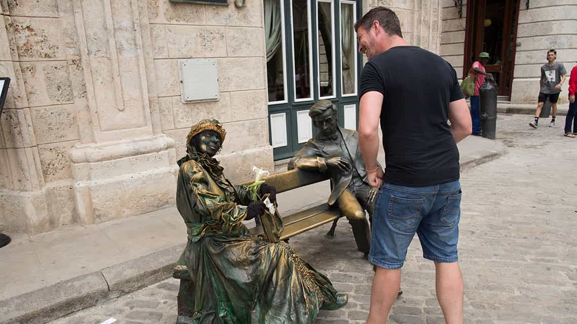 Turista conversa con estatua viviente en la Plaza de San Francisco de Asis, justo al lado de la estatua de Chopin