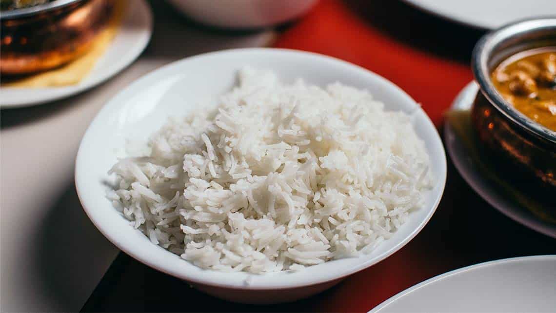 Un plato de arroz blanco en la mesa junto al resto del menu