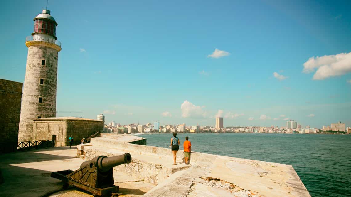 Una pareja contempla la ciudad de La Habana desde los muros de complejo Morro-Cabana