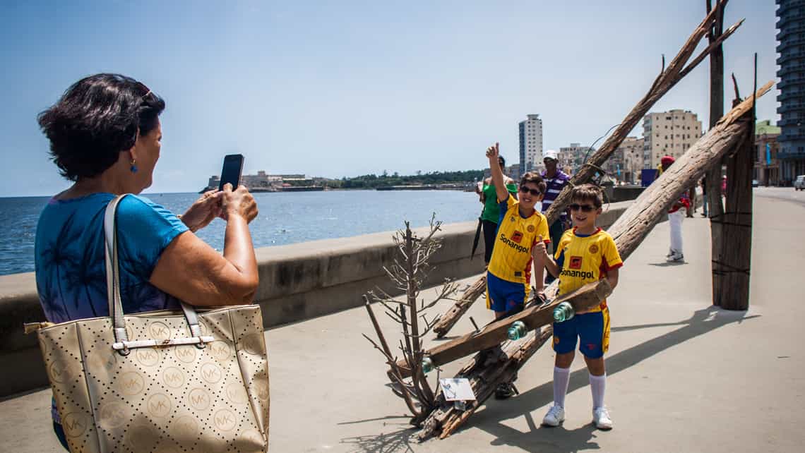Ninos posando para una foto en una de las instalaciones en la Bienal de La Habana