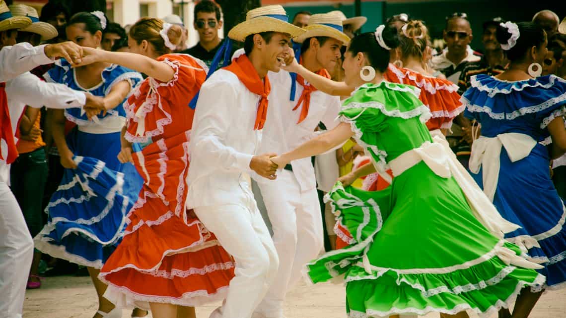 Un grupo de bailadores con trajes tradicionales cubanos disfrutan de los ritmos campesinos