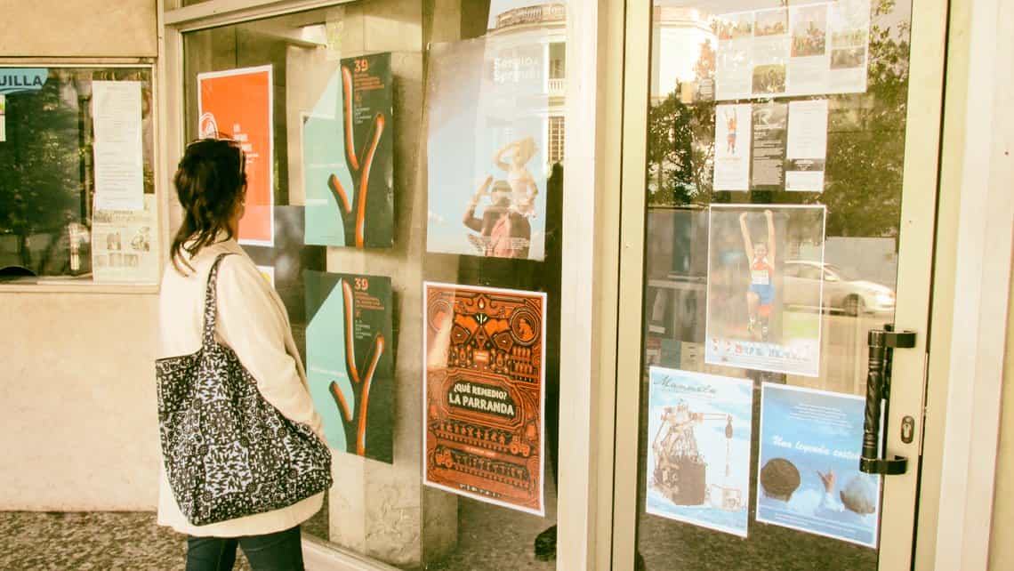 Una muchacha revisa la cartelera del cine en los dias del Festival de Cine Latinoamericano