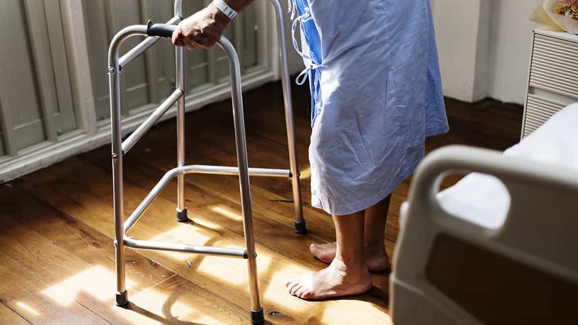 Paciente camina con ayuda en un centro de rehabilitacion