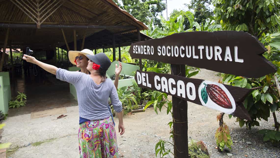 Turistas se toman un selfie frente al cartel que anuncia el comienzo de La ruta del Cacao
