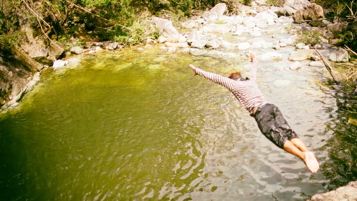 Muchacho se lanza a nadar en una poza natural