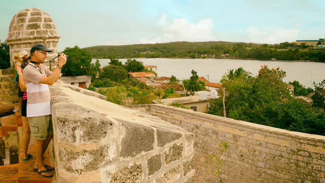 Turista toma fotos de la entrada a la bahia de Cienfuegos desde el Castillo del Jagua