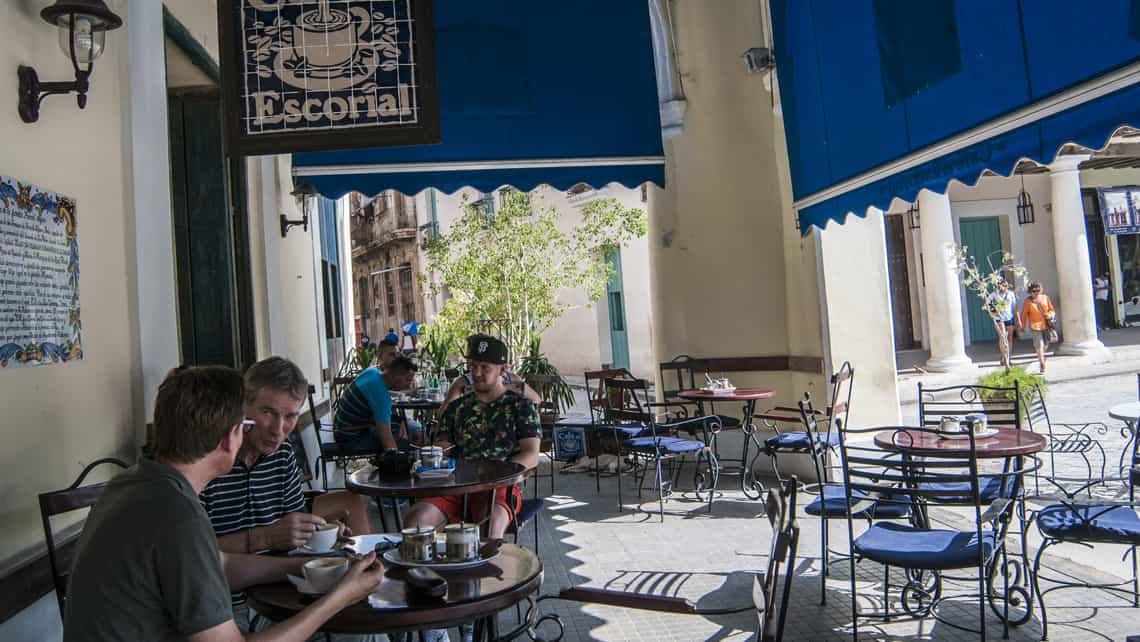 Clientes de El Escorial disfrutan el sabroso cafe cubano en un espacio exterior con vistas a la Plaza Vieja
