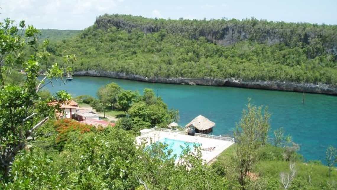 Vista de la piscina de la villa desde uno de los senderos con la ensenada de Guajimico de fondo 