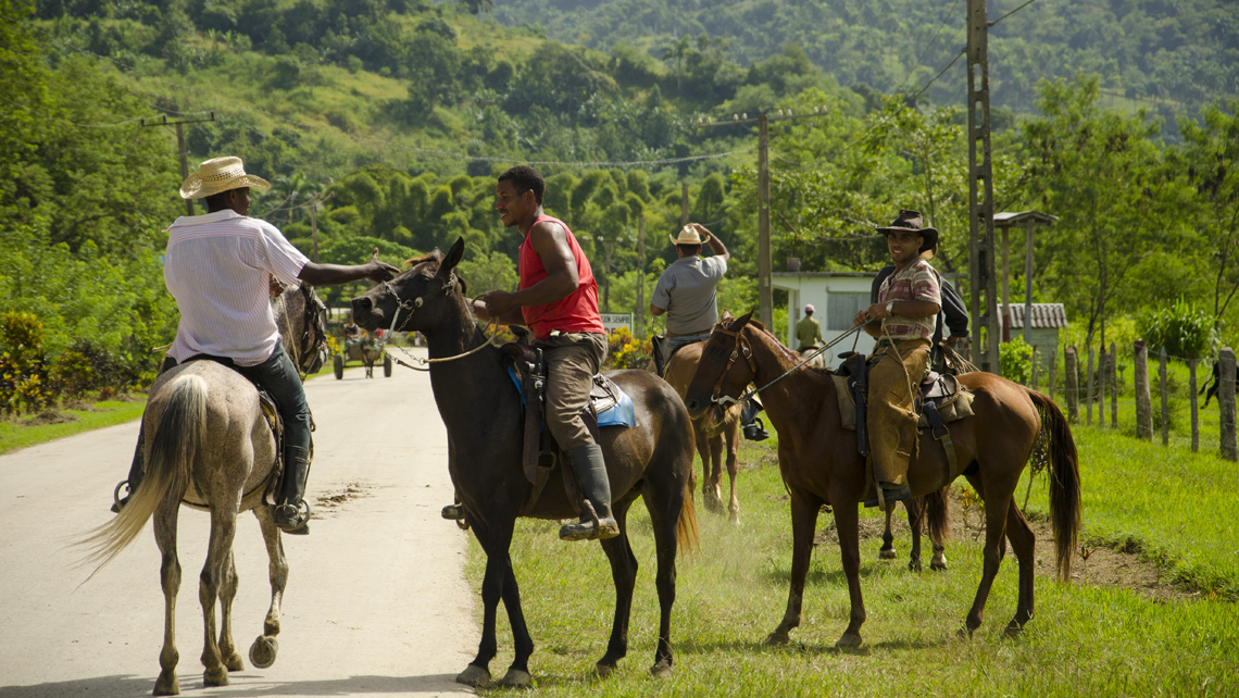 Locales montados en caballos se saludan en una zona rural de Guantanamo