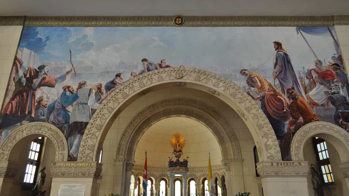 Imagen de la Virgen de la Caridad del Cobre rodeada por majestuosos murales en la Iglesia Jesús de Miramar