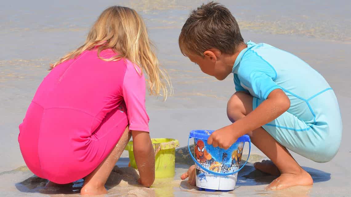 Niños jugando con la arena de la playa