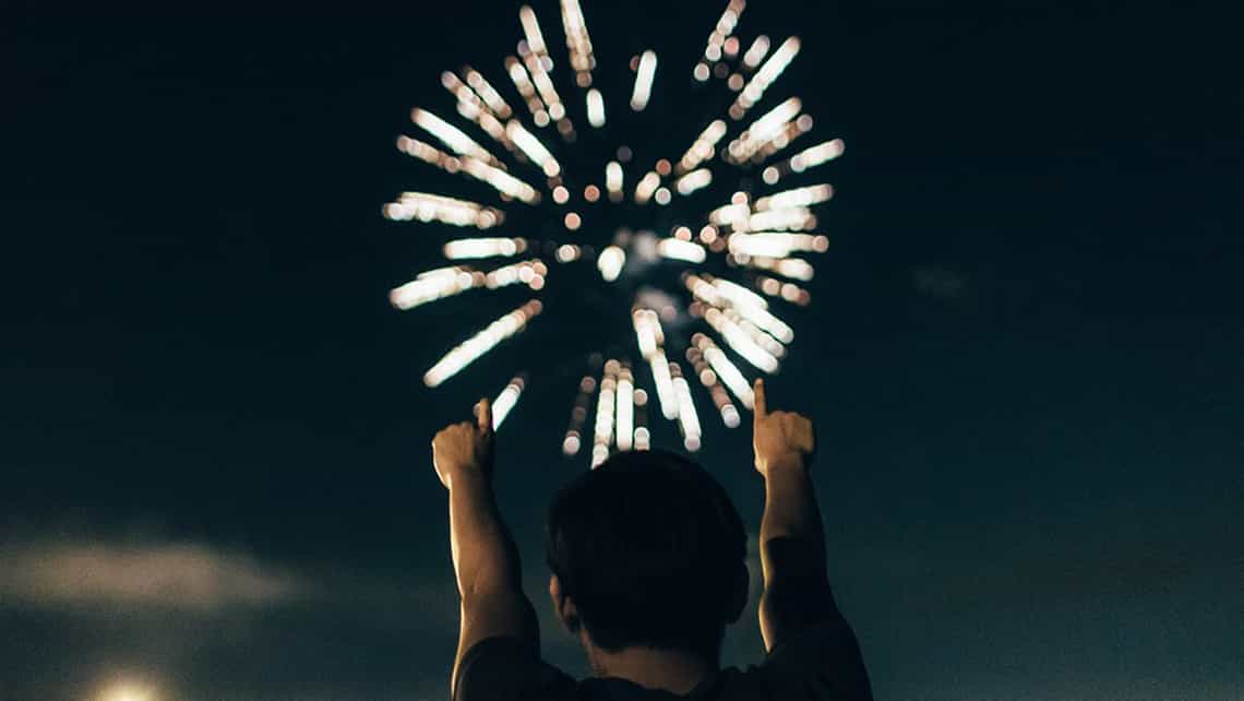 Persona observa fuegos artificiales durante una celebración