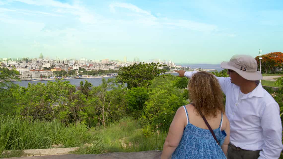 Viajeros disfrutan vistas de la ciudad de La Habana desde Casablanca en el otro lado de la Bahia