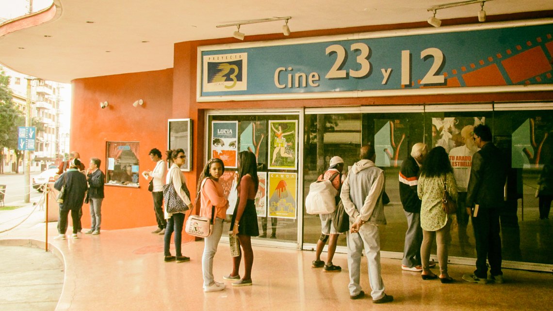 Un grupo de personas espera para entrar al cine 23 y 12