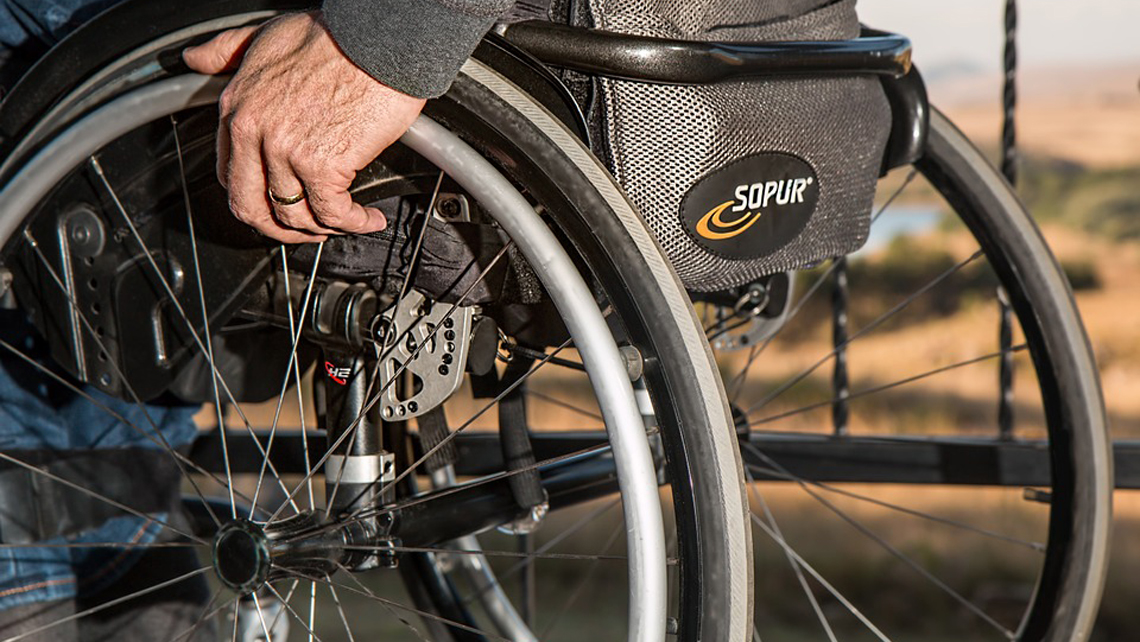 Paciente con dificultad para caminar utiliza una silla de ruedas