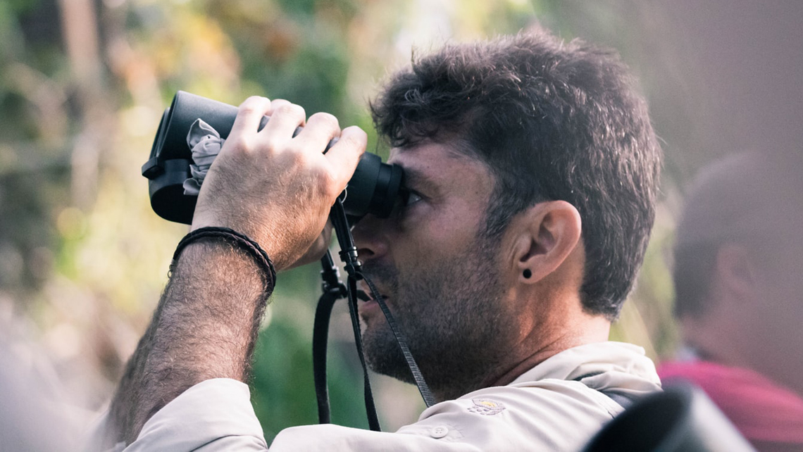 Amante del ecoturismo usando binoculares
