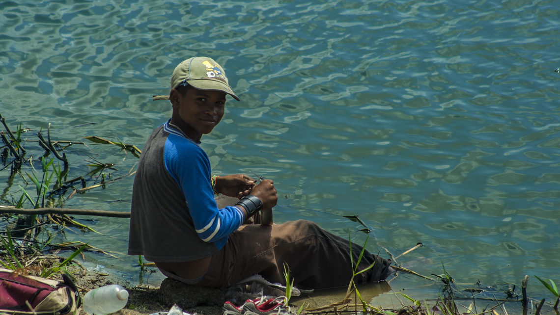 Niño camagueyano sentado a la orilla del lago