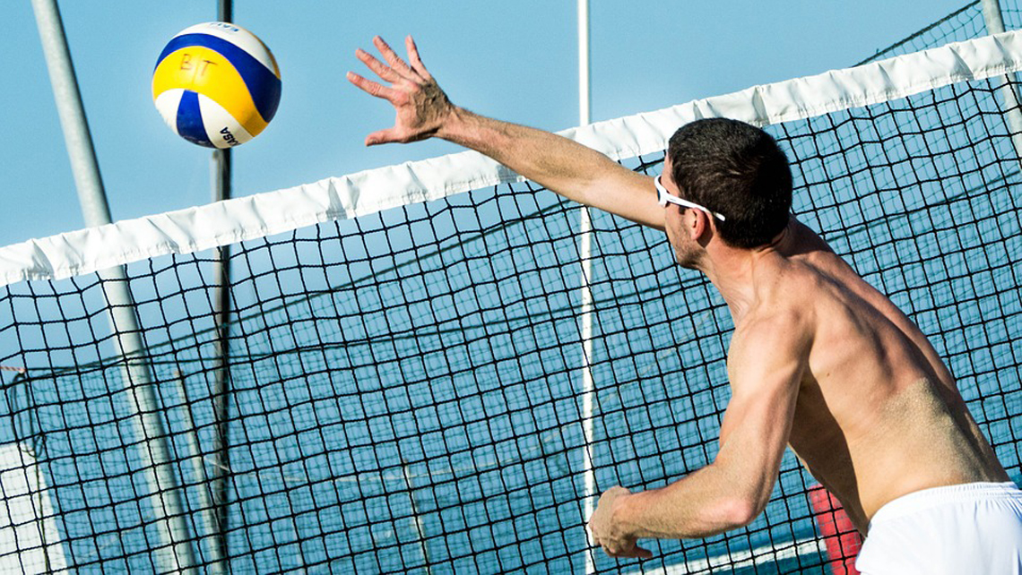 Jugador de voleibol de playa rematando la pelota