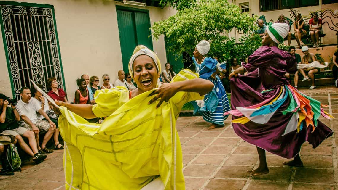 Bailarines danzan ritmos tradicionales cubanos durante espectaculo con viajeros